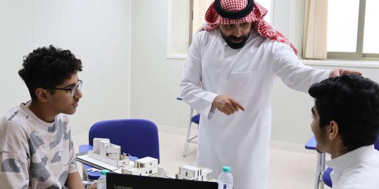 Saudi teacher explaining to two students at The Academic Talent Enrichment Program.